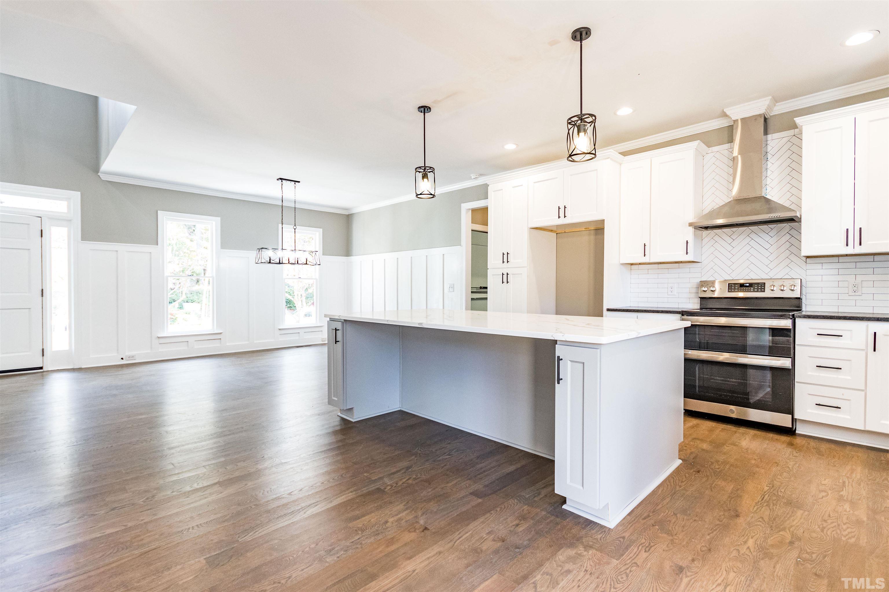 8105 Laurel Mountain Road Raleigh, NC 27613 - Photo 2 of 26 a kitchen with stainless steel appliances kitchen island granite countertop a refrigerator a oven a stove and a wooden floors