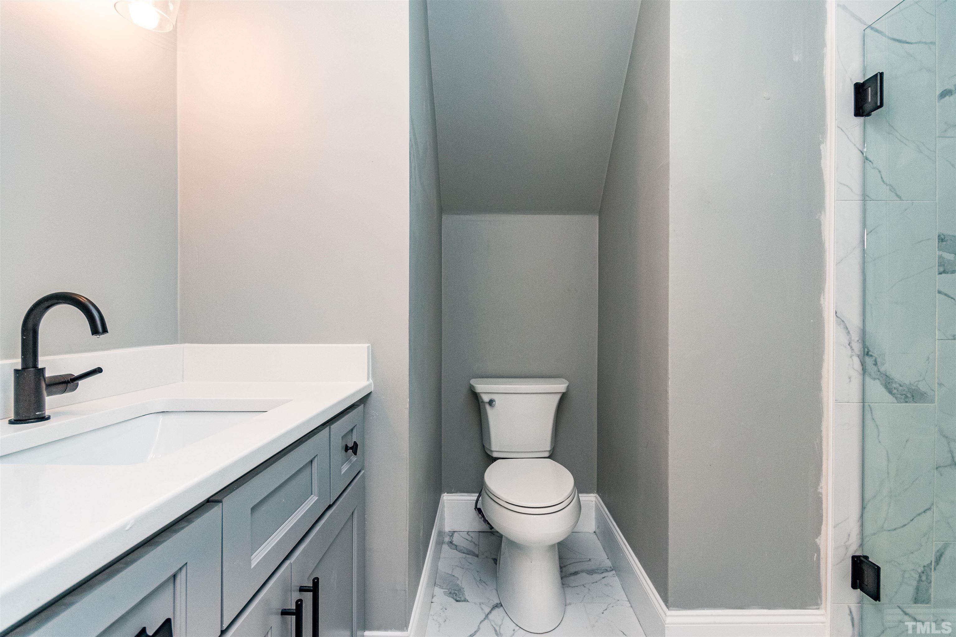 8105 Laurel Mountain Road Raleigh, NC 27613 - Photo 21 of 26 a bathroom with a toilet sink and mirror