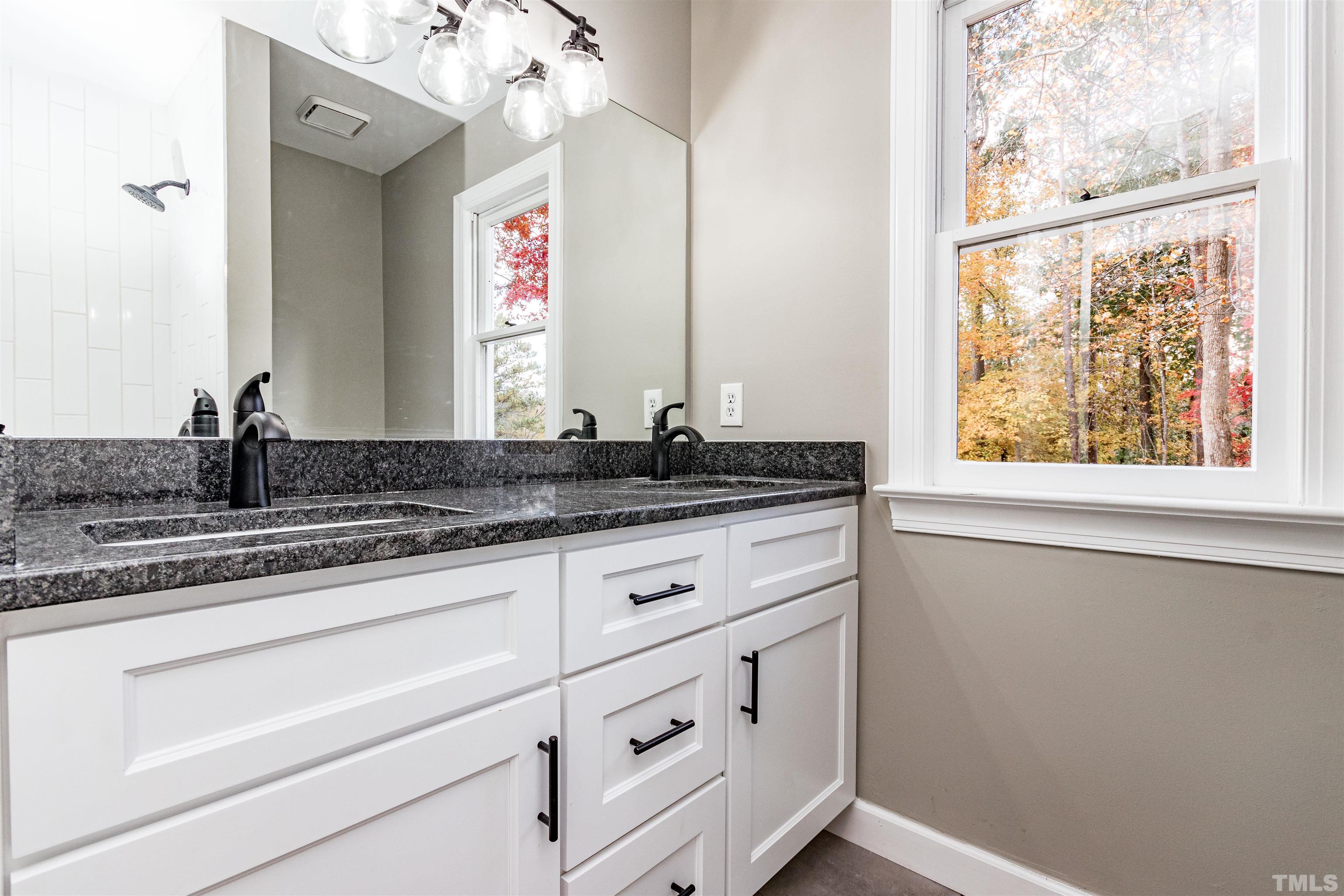 8105 Laurel Mountain Road Raleigh, NC 27613 - Photo 9 of 26 a bathroom with a granite countertop sink and a window