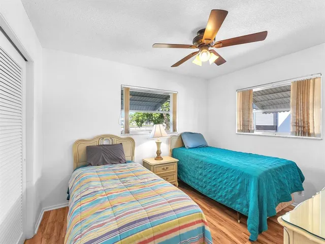 a bedroom with 2 bed and a window