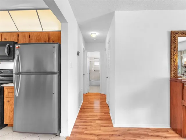 a view of a hallway with wooden floor and a cabinet