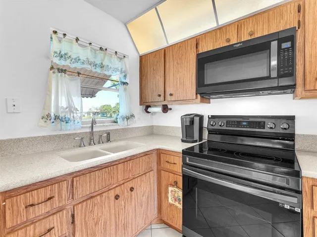 a kitchen with stainless steel appliances granite countertop a sink and microwave