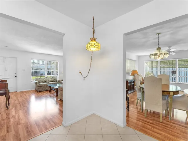 a living room with dining table and a chandelier