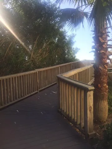 a view of a balcony with wooden floor and fence