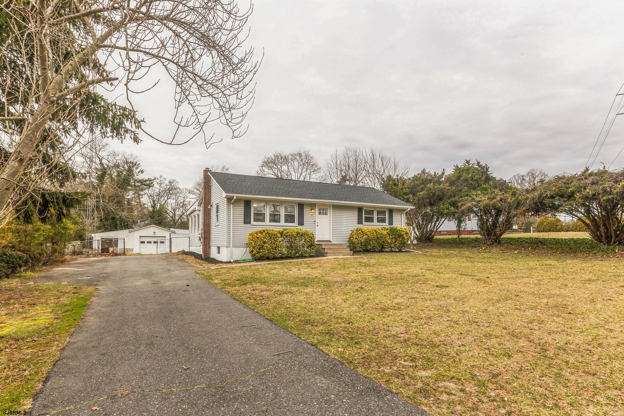 a front view of a house with a yard and trees