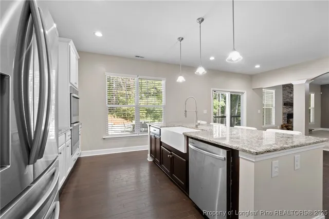 a kitchen with stainless steel appliances granite countertop a sink a stove and a refrigerator