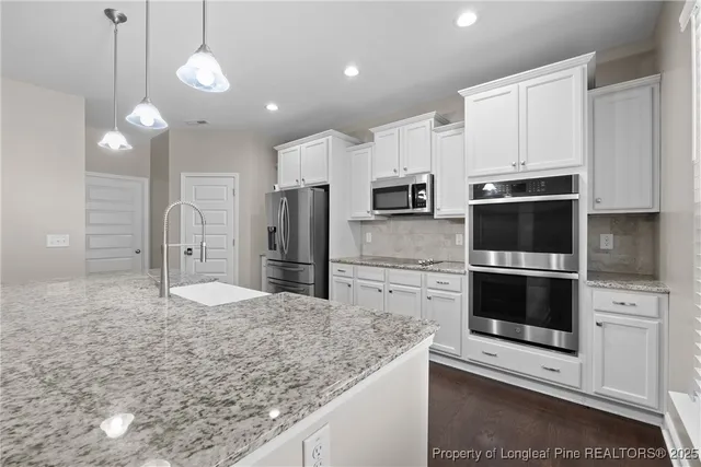 a kitchen with stainless steel appliances granite countertop a stove a microwave and a refrigerator