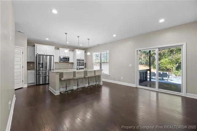 a open kitchen with stainless steel appliances kitchen island wooden floors and living room view