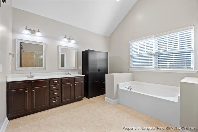 a spacious bathroom with a tub sink and mirror