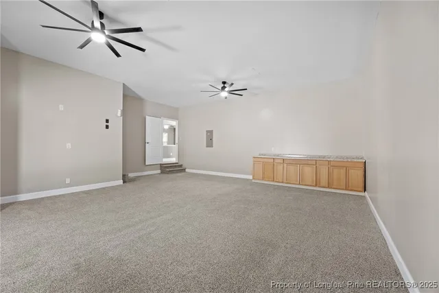 an empty room with ceiling fan and window