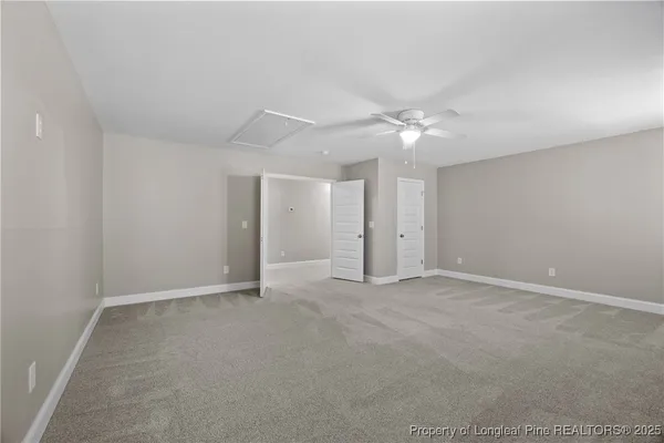 an empty room with a ceiling fan and a window