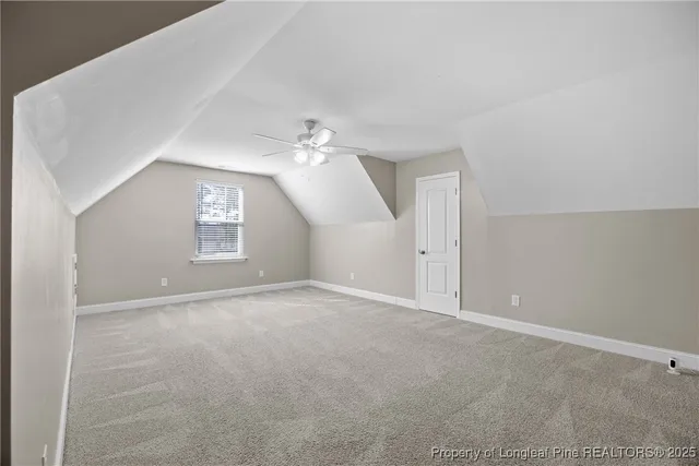 an empty room with windows and chandelier fan