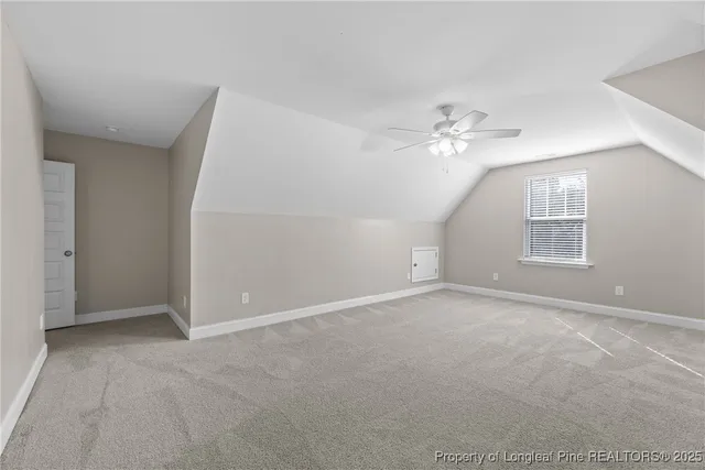 an empty room with chandelier fan and windows