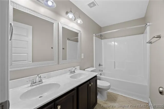 a bathroom with a granite countertop sink toilet a large mirror a bathtub and shower