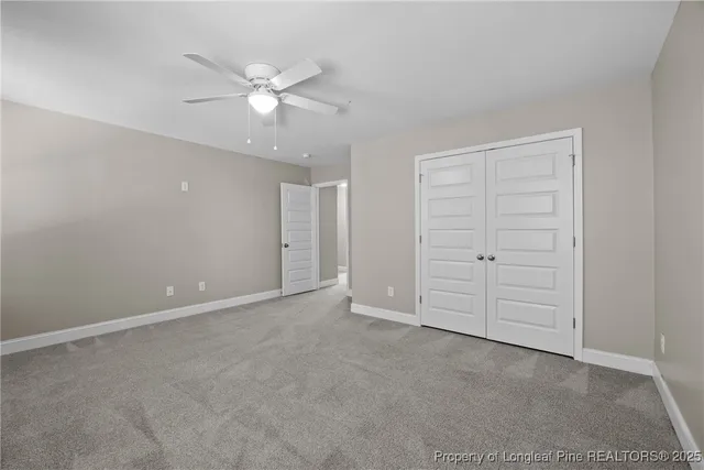 an empty room with closet and fan