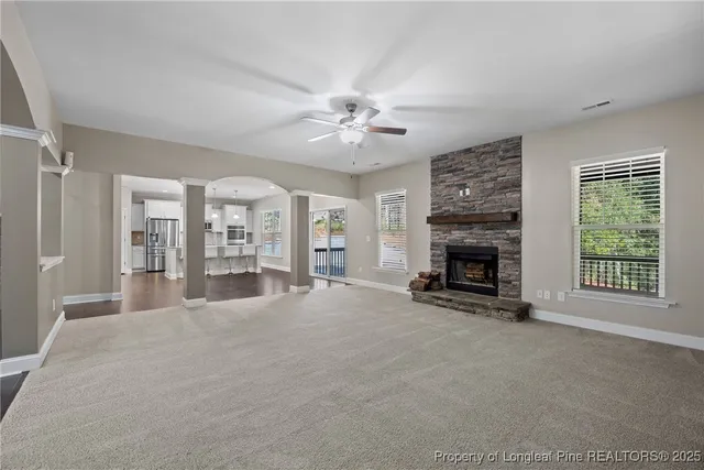 a view of an empty room with a fireplace and a window