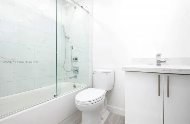 a bathroom with a bathtub shower sink vanity and toilet