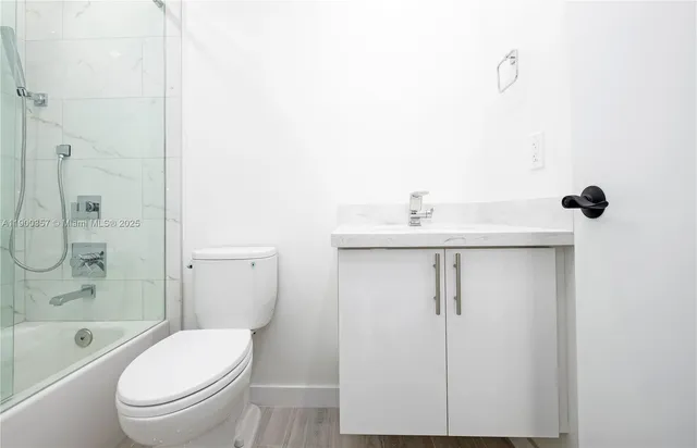 a bathroom with a shower a toilet and a sink