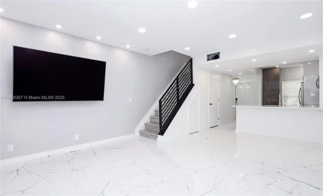 a view of a living room with flat screen tv and kitchen view