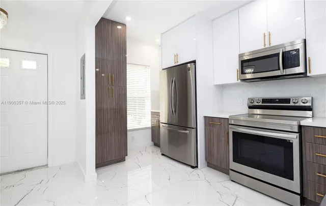 a kitchen with stainless steel appliances granite countertop a refrigerator and a stove top oven