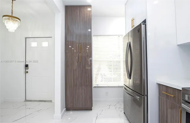a view of a kitchen with a refrigerator and window