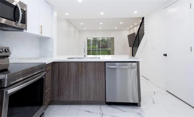 a kitchen with a sink a microwave and cabinets