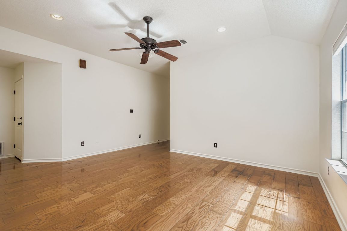 1708 Rusty Nail Loop Round Rock, TX 78681 - Photo 3 of 13 Spare room with hardwood / wood-style flooring, lofted ceiling, a ceiling fan, and recessed lighting