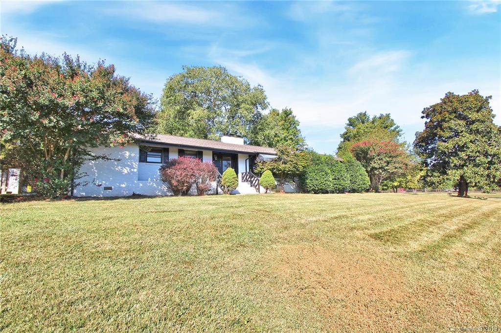 a front view of house with yard and trees in the background