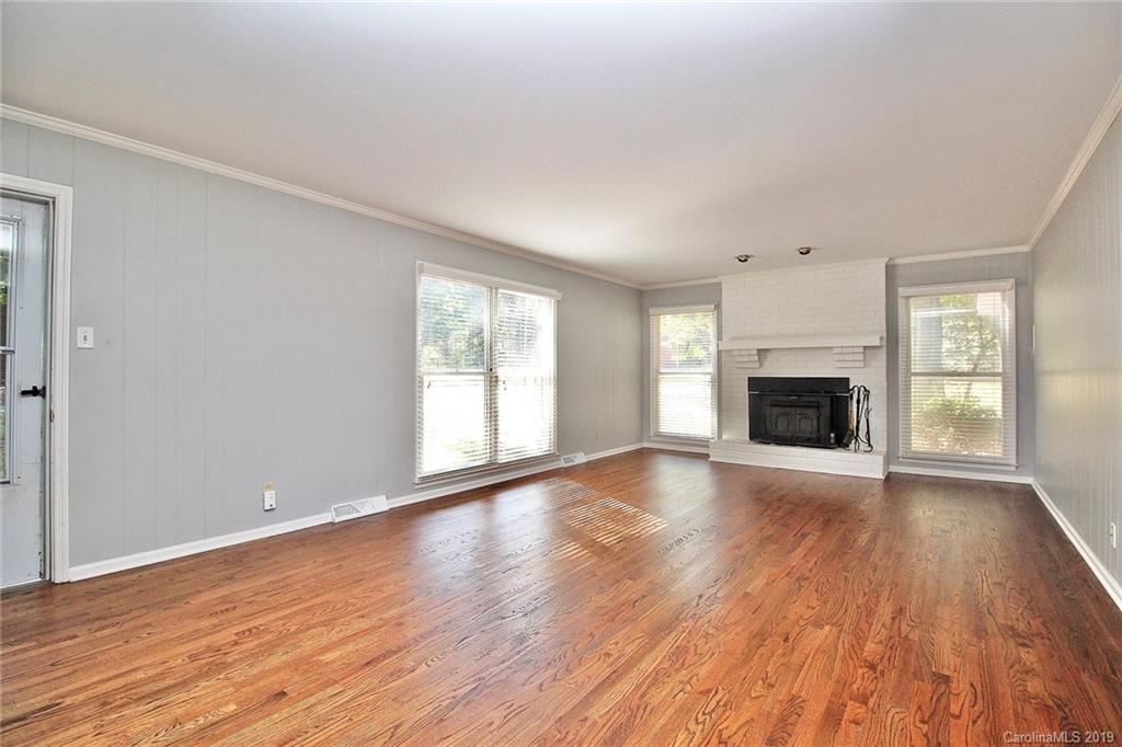 3399 Pleasant Road Fort Mill, SC 29708 - Photo 48 of 48 an empty room with wooden floor fireplace and windows