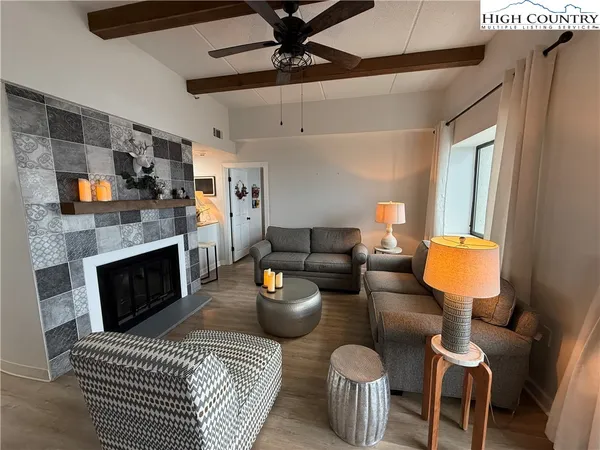 a living room with furniture a flat screen tv and a fireplace