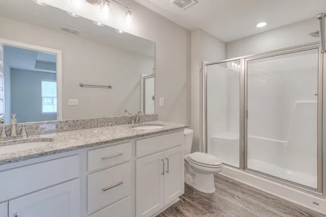 a bathroom with a granite countertop sink toilet and shower