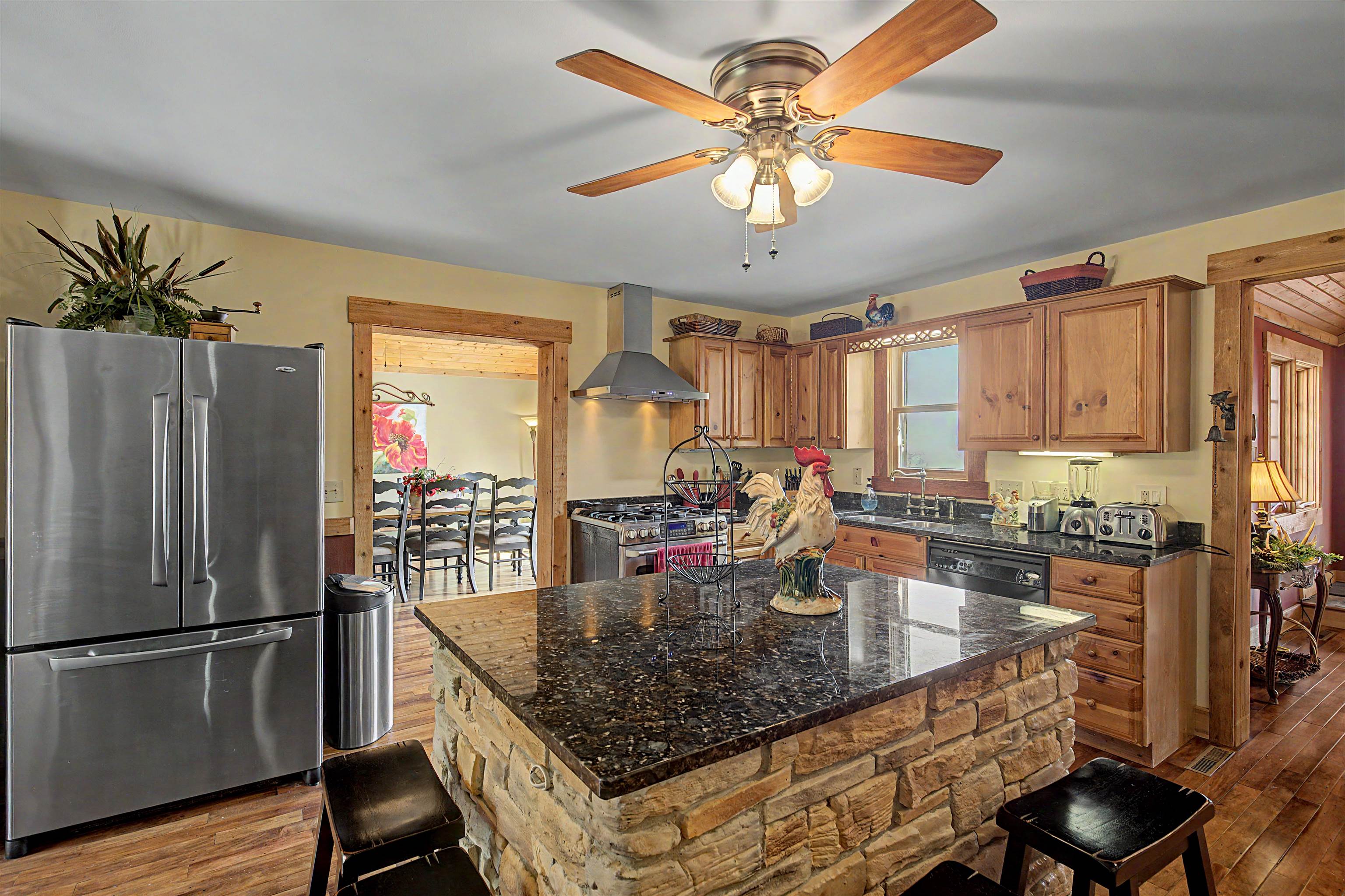 2287 West Hanover Road Hanover, IL 61041 - Photo 14 of 65 a kitchen with stainless steel appliances granite countertop a refrigerator a stove top oven a sink dishwasher and chairs with wooden floor