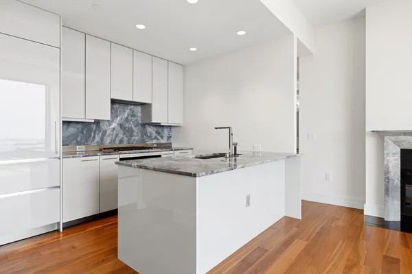 a kitchen with a sink cabinets and wooden floor