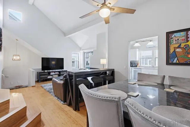 a living room with furniture a flat screen tv and kitchen view