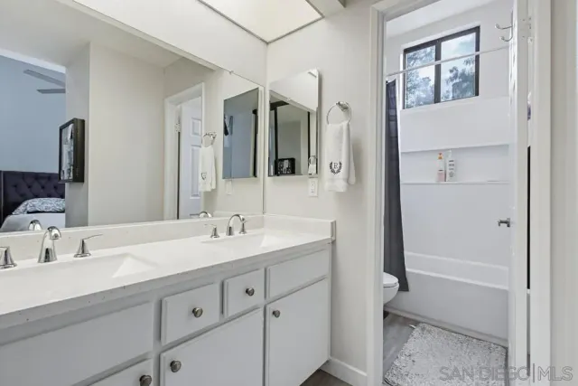 a bathroom with a double vanity sink mirror and toilet
