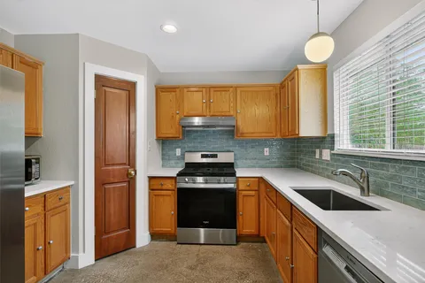 a kitchen with a sink a stove and cabinets