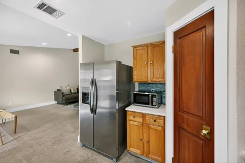 a kitchen with stainless steel appliances granite countertop a refrigerator and a stove top oven