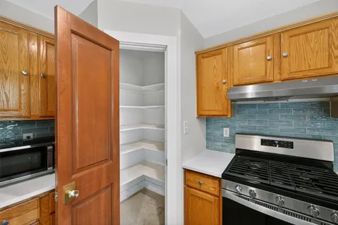 a kitchen with wooden cabinets and a stove top oven