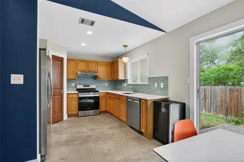 a large kitchen with stainless steel appliances granite countertop a stove and a sink