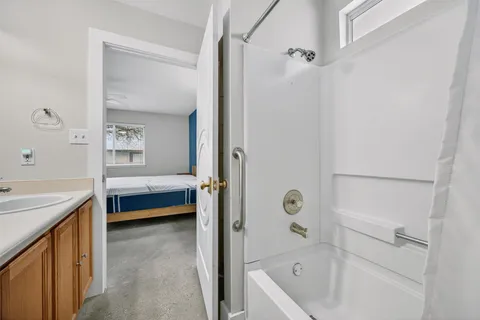 a bathroom with a tub a sink and a window