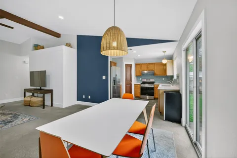 a kitchen with stainless steel appliances granite countertop a refrigerator a stove a microwave oven a sink with island chairs and wooden floor