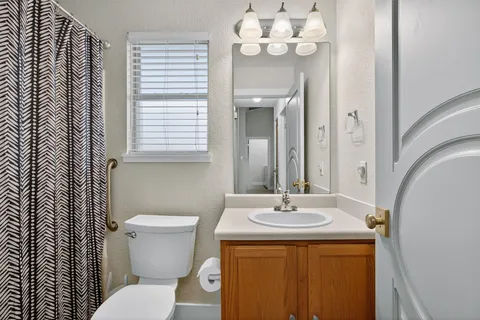a bathroom with a sink a toilet and a mirror