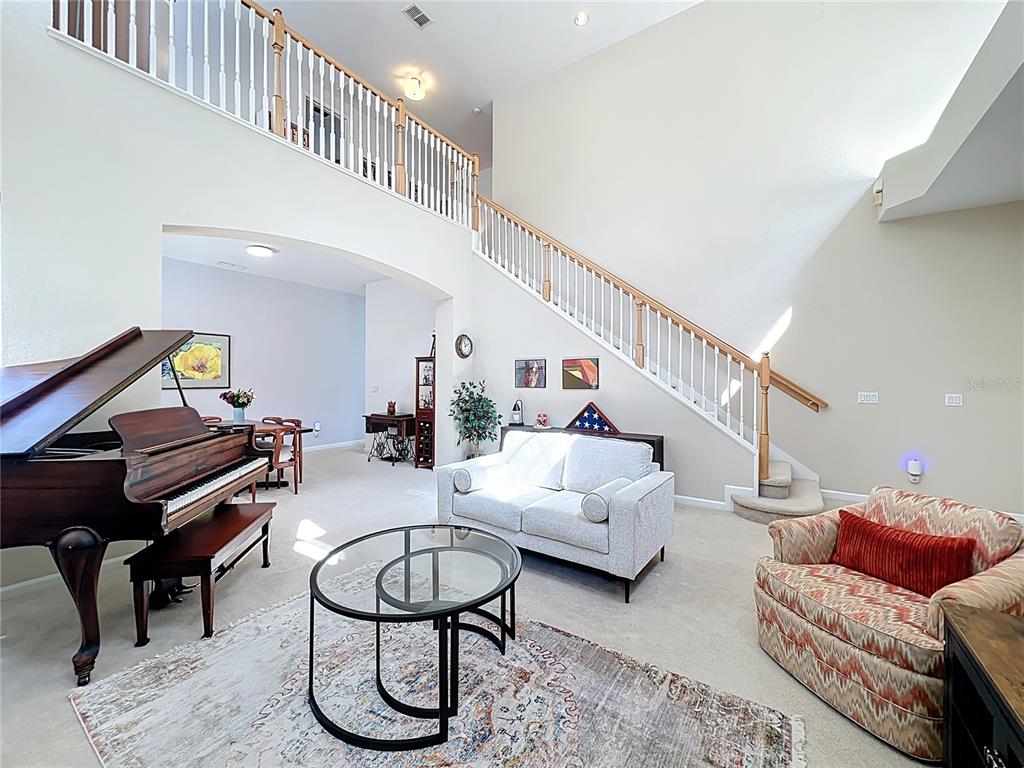 6573 Helmsley Circle Windermere, FL 34786 - Photo 11 of 54 a living room with furniture a piano and wooden floor