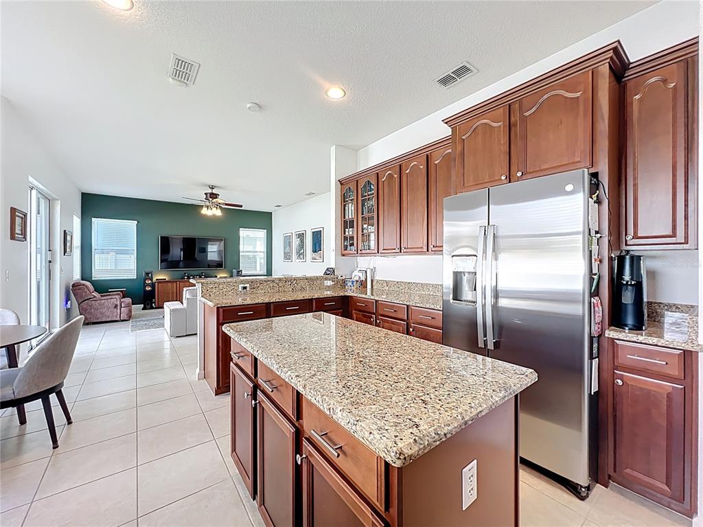 6573 Helmsley Circle Windermere, FL 34786 - Photo 15 of 54 a kitchen with stainless steel appliances granite countertop a kitchen island a cabinets a sink and a refrigerator