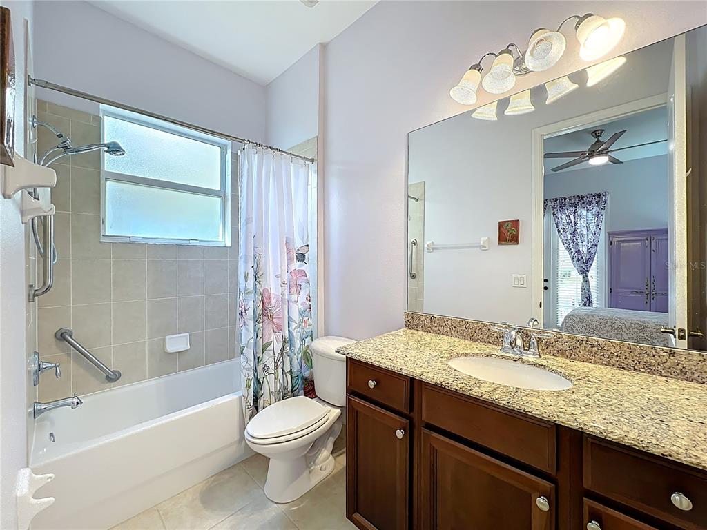 6573 Helmsley Circle Windermere, FL 34786 - Photo 27 of 54 a bathroom with a granite countertop sink toilet a large mirror a bathtub and shower