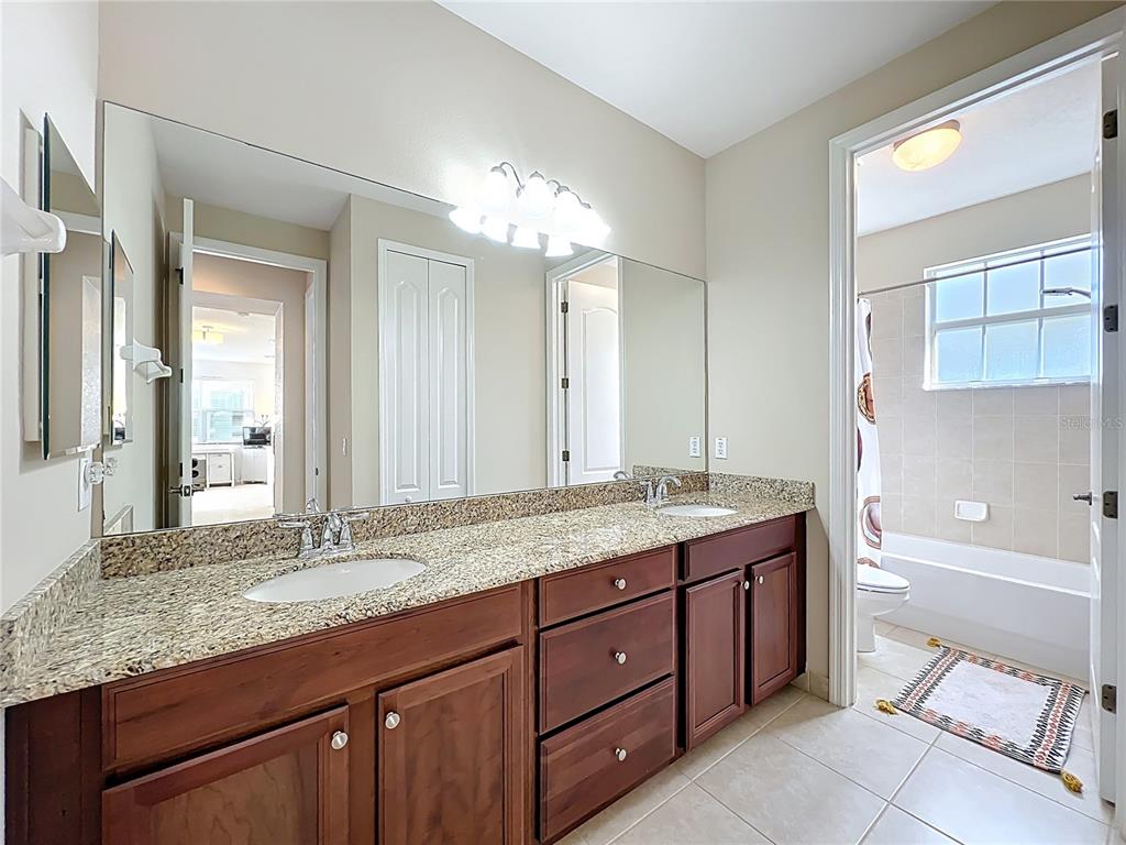 6573 Helmsley Circle Windermere, FL 34786 - Photo 45 of 54 a bathroom with a granite countertop double vanity sink and a mirror