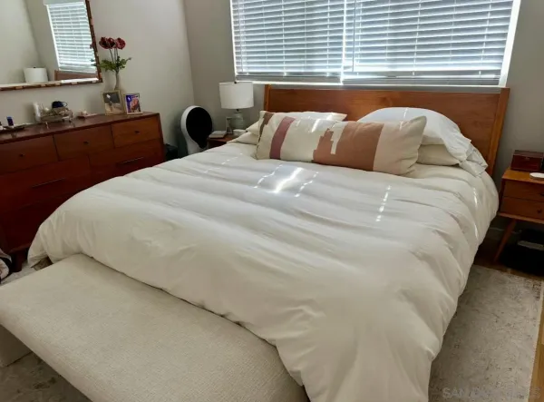 a bed sitting in a bedroom next to a window