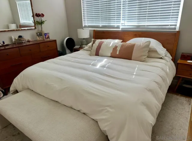 a bed sitting in a bedroom next to a window