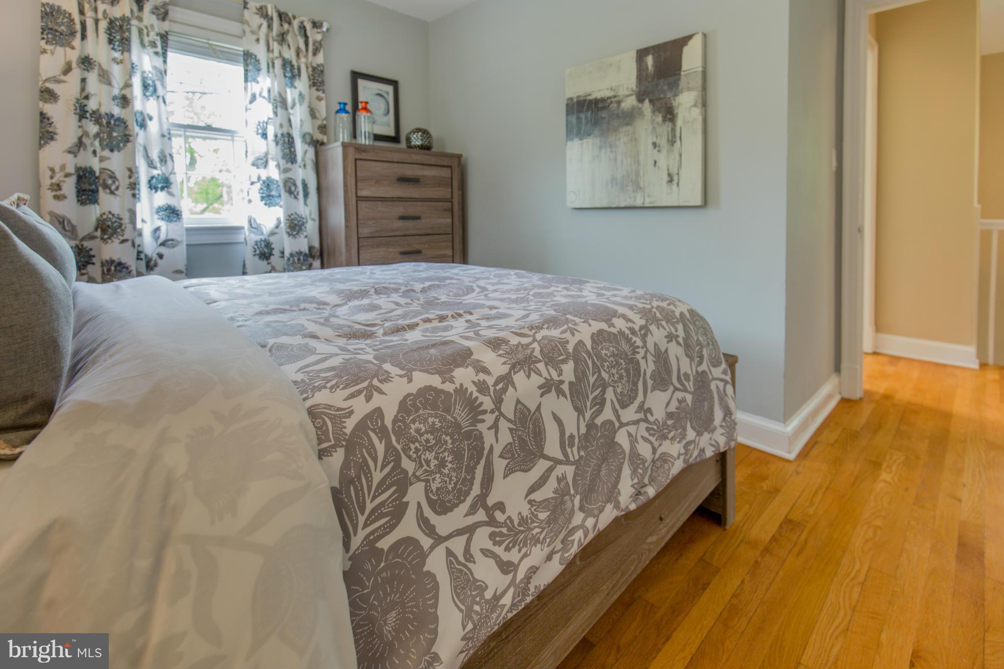 310 Brewster Court Silver Spring, MD 20901 - Photo 19 of 30 a bedroom with a bed and dresser with wooden floor