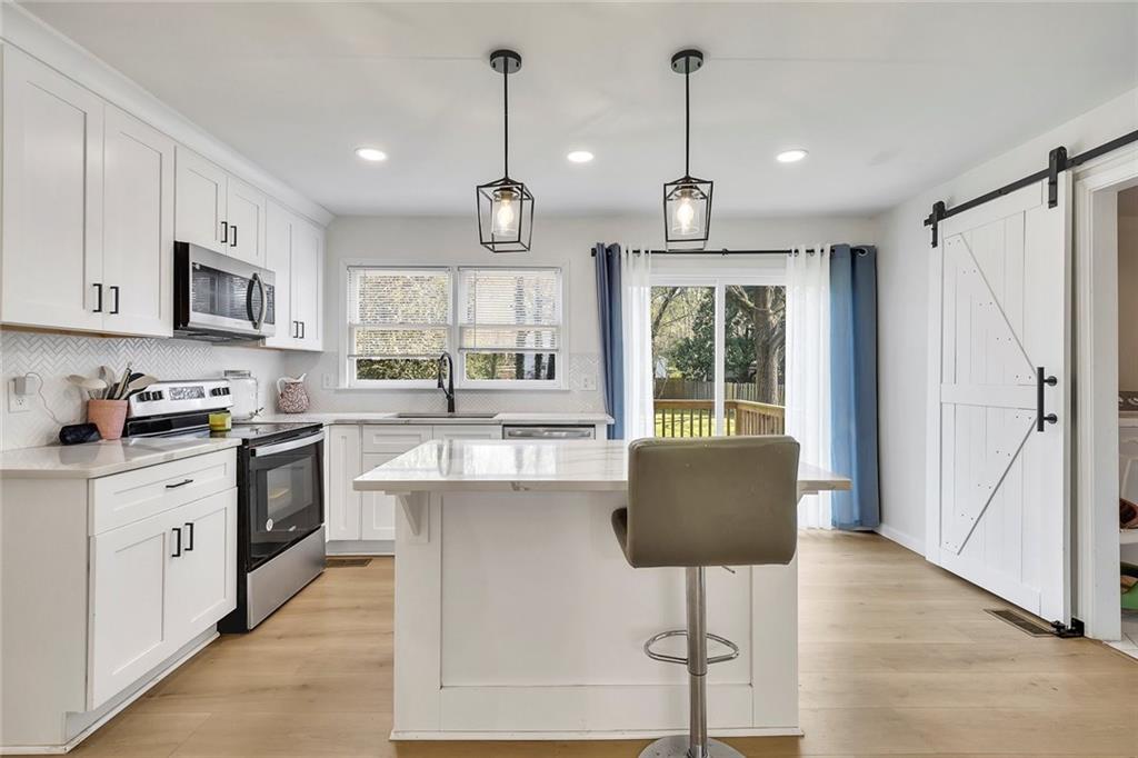 2328 Carnes Road Jonesboro, GA 30236 - Photo 11 of 36 a kitchen with kitchen island granite countertop a stove a sink a center island a refrigerator and a window